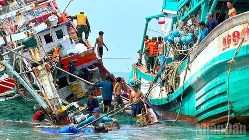 Cán bộ, chiến sĩ Đồn Biên phòng Hòn Chuối và ngư dân hỗ trợ đưa người và tài sản tàu cá bị chìm lên tàu cứu nạn. 