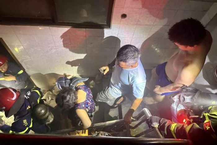 Hai nạn nhân được cảnh sát PCCC dìu ra ngoài an toàn.